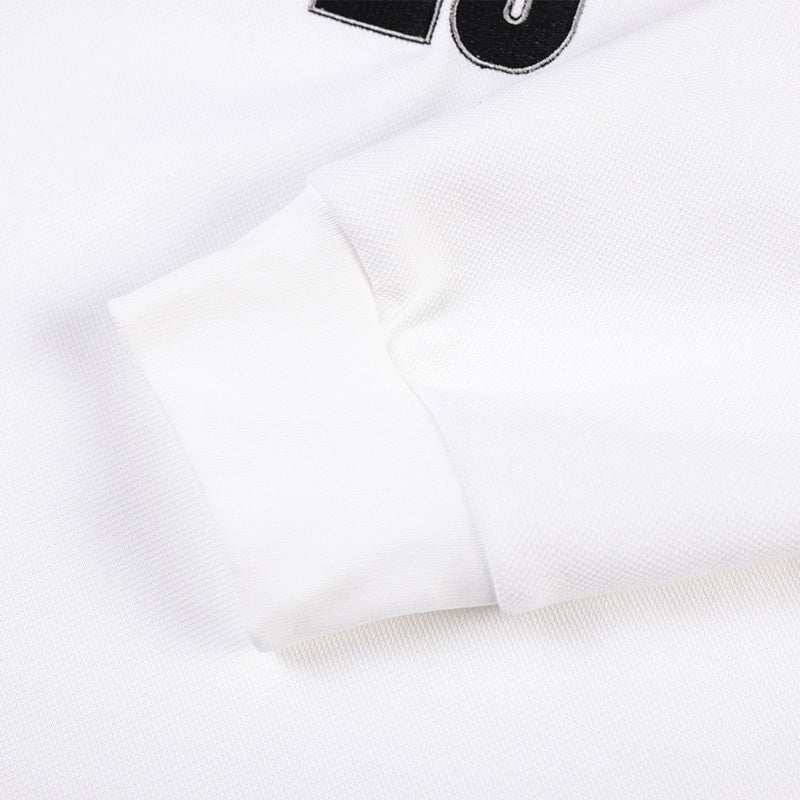 Close-up of white jersey sleeve cuff and stitched fabric texture