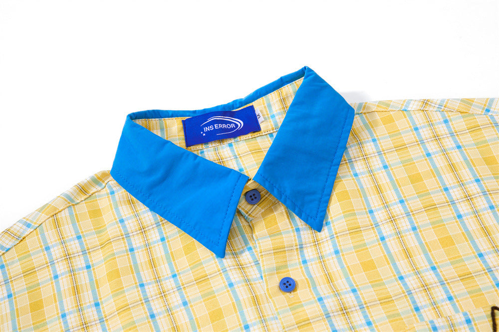 Close-up of blue collar and upper front button placket on yellow plaid shirt