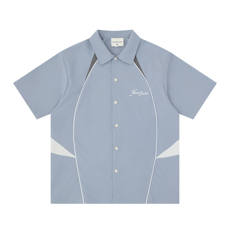 Men's color block racing short sleeve shirt in steel blue with grey and white contrast panels and embroidered chest logo