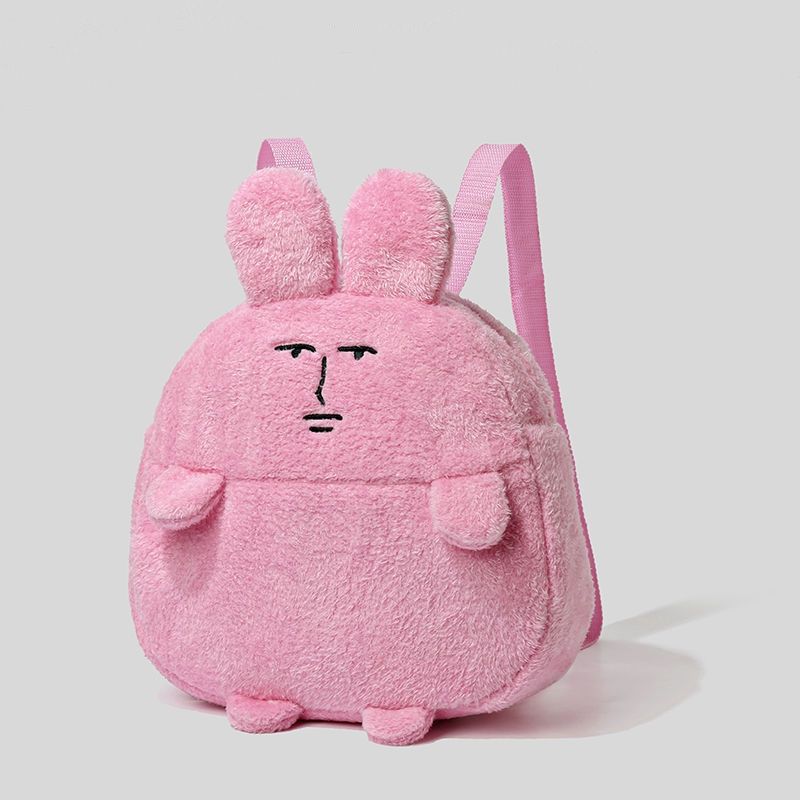 The Seakoff Quirky Pink Bunny Plush Backpack showcases a cartoonish bunny with a serious face, complete with ears, pink straps, and small limbs. Perfect for everyday use, it's set against a plain gray background.