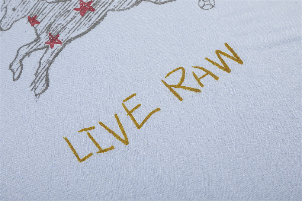 Close-up of yellow Live Raw text on light blue tee front graphic
