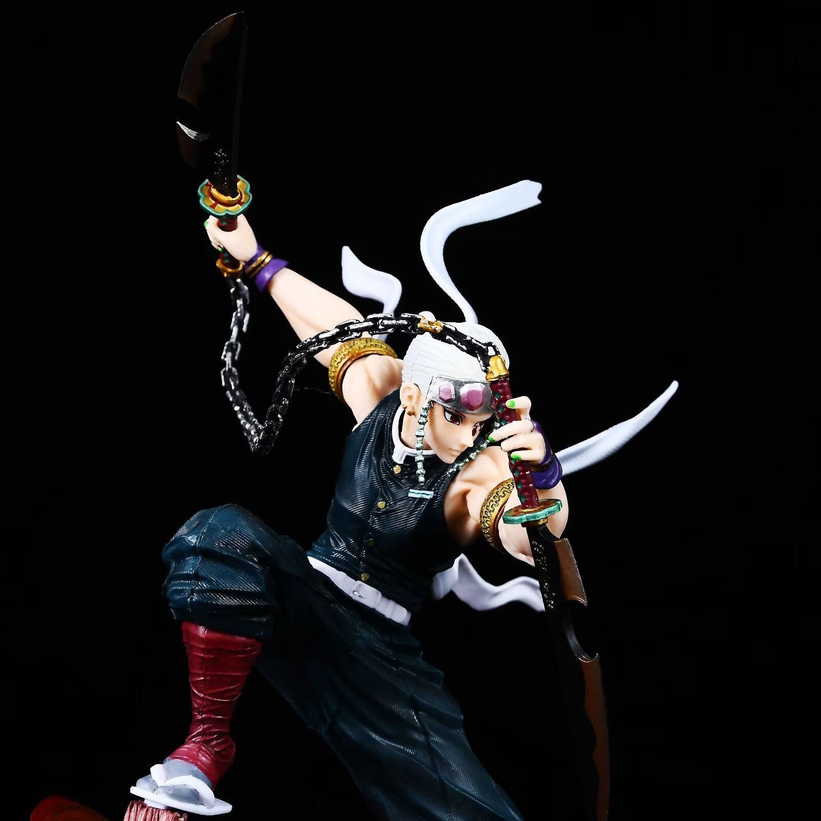 The 27cm Tengen Uzui Battle Sound Pillar Figure from Demon Slayer, a high-quality PVC collectible, showcases the character with white hair, a dark outfit, a headband with a purple gem, and dynamic dual blades amid flowing ribbons and chains against a black background.