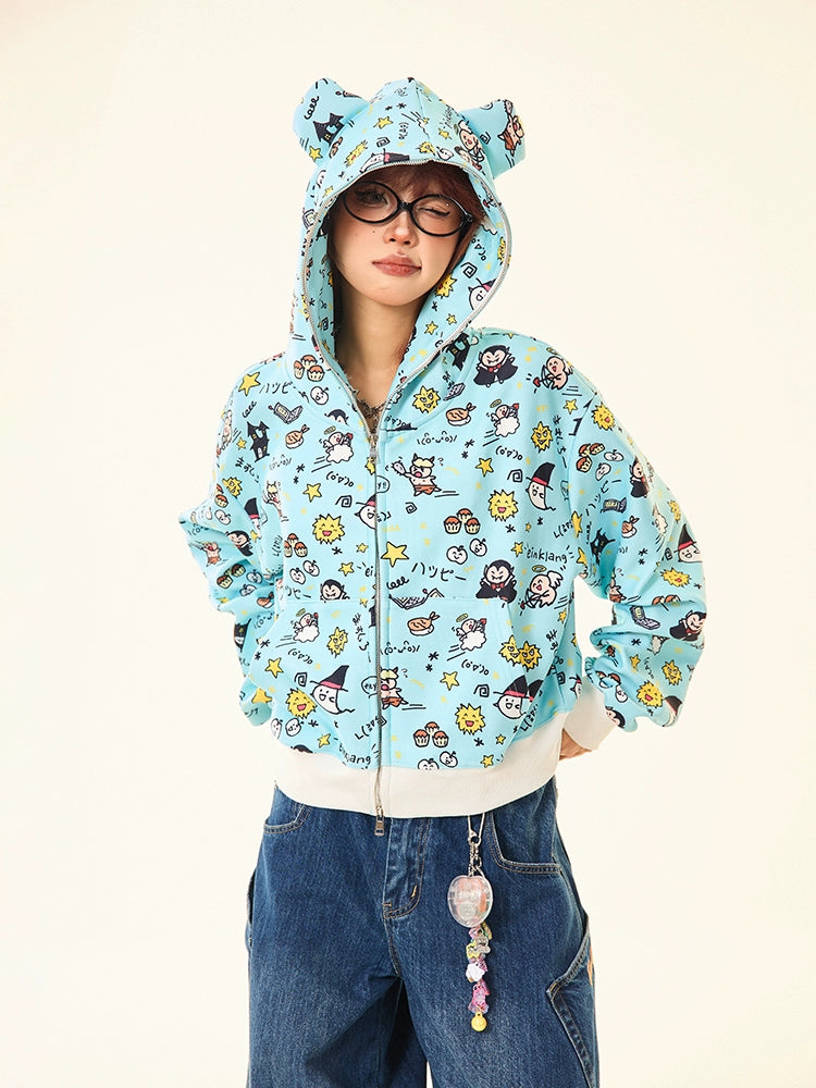 Wearing a Seakoff Kawaii Cartoon Bear Hoodie with cartoon prints and bear ears, a person sports glasses and short hair, teamed with loose blue jeans. A colorful bead keychain enhances their whimsical streetwear look.