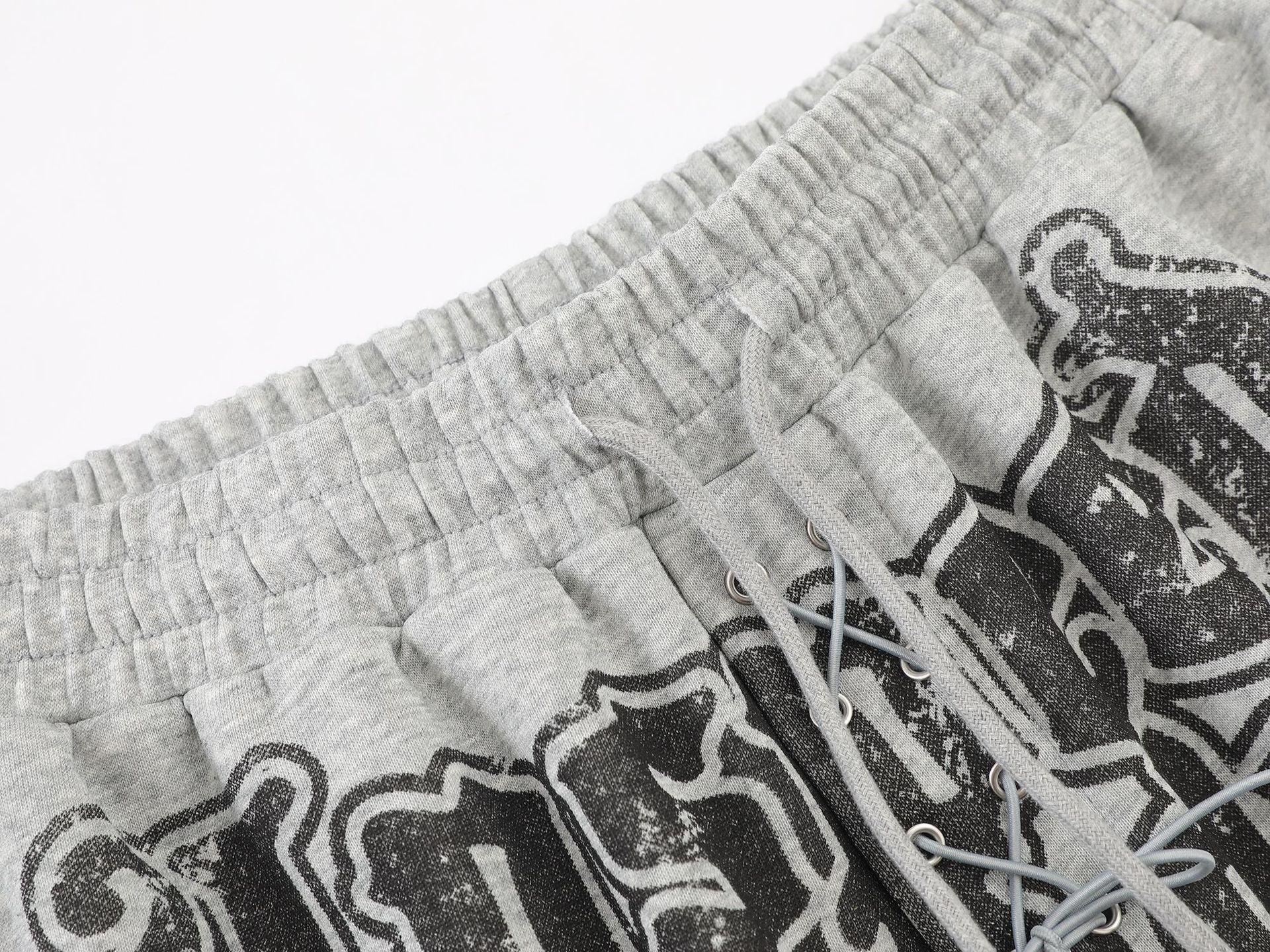 Pantalon de survêtement à jambes larges avec graphisme graffiti et ourlet orné de détails métalliques
