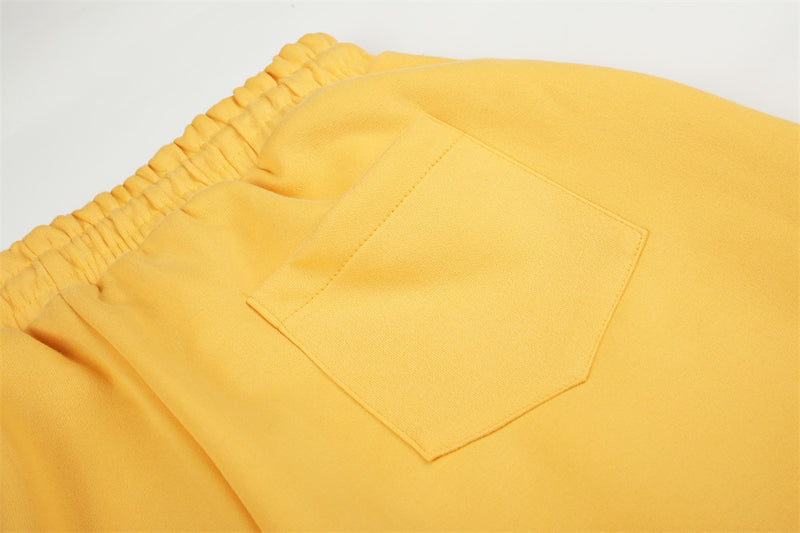 Close-up of yellow sweatpants back pocket and elastic waistband