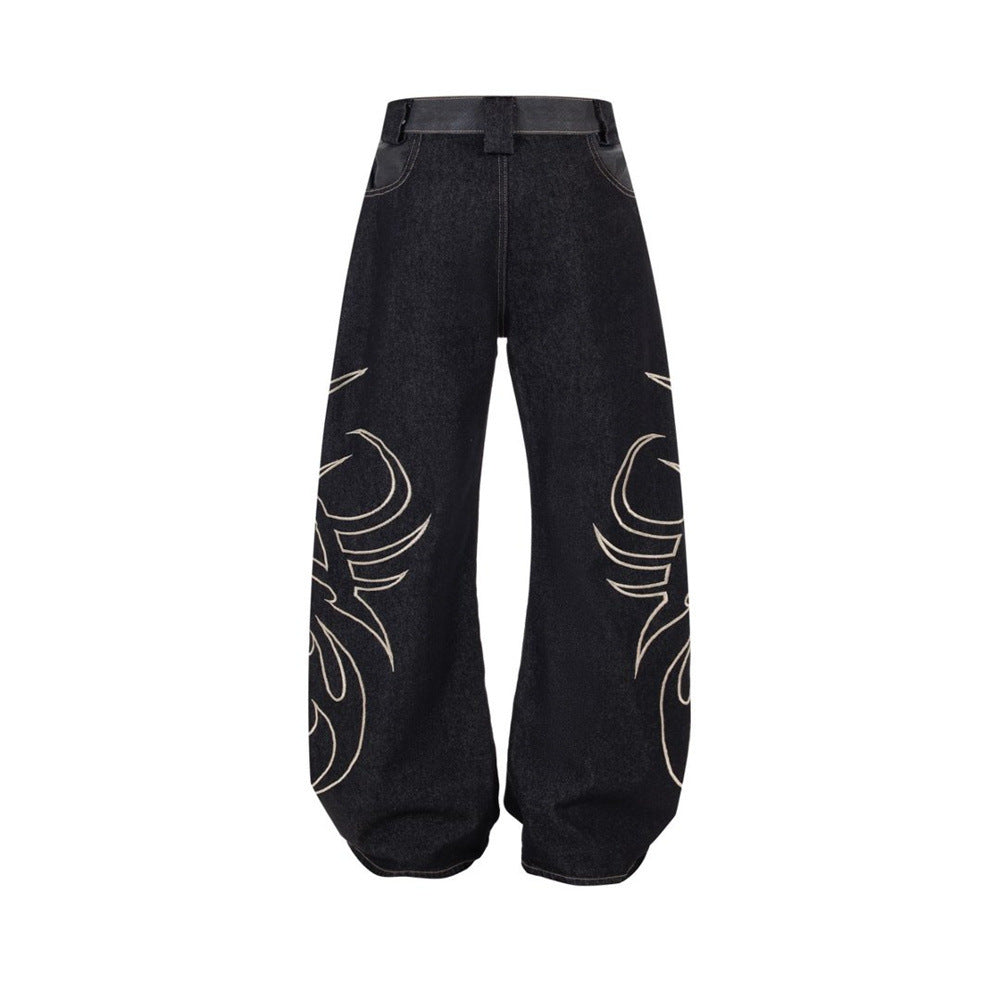 Back view of black wide-leg jeans with tribal flame embroidery along both legs
