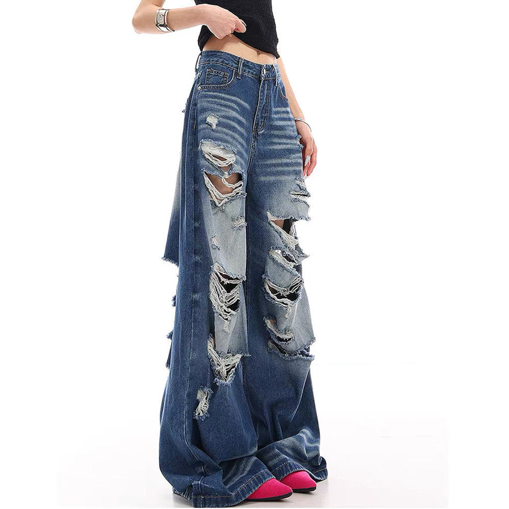 Side view of baggy blue distressed jeans with ripped legs on a model