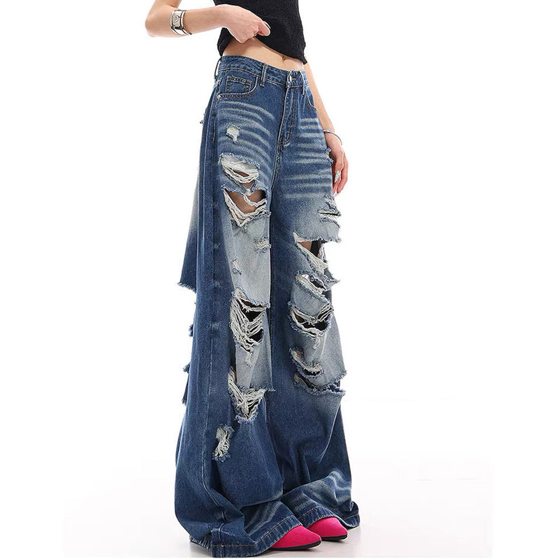 Side view of baggy blue distressed jeans with ripped legs on a model