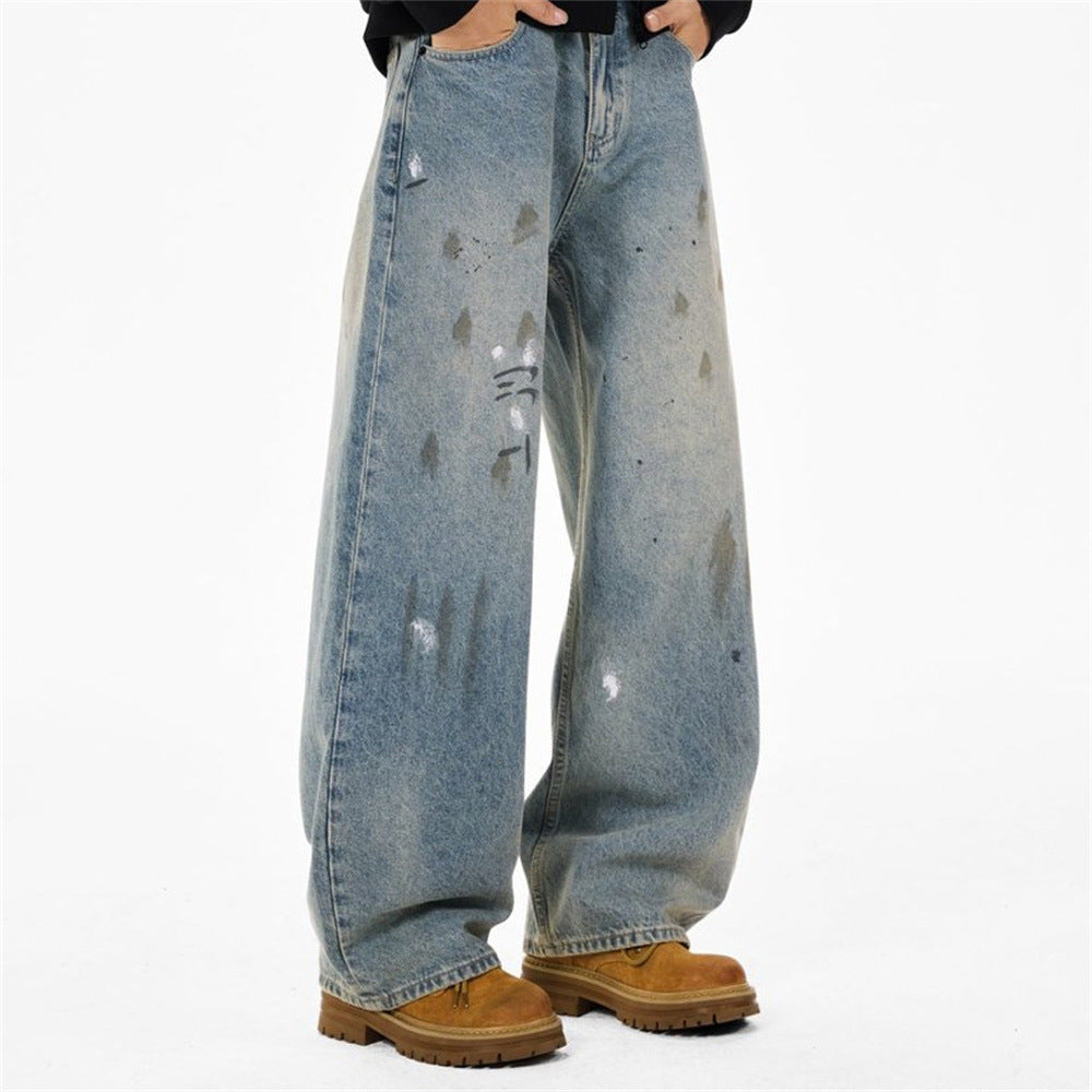 Front view of wide leg light wash jeans with paint splatter distressing and tan boots