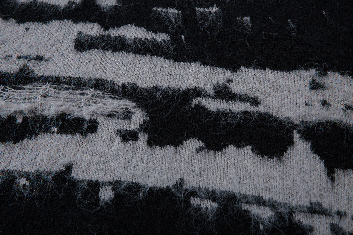 Detailed view of fuzzy black and gray jacquard knit texture with uneven horizontal stripe edges