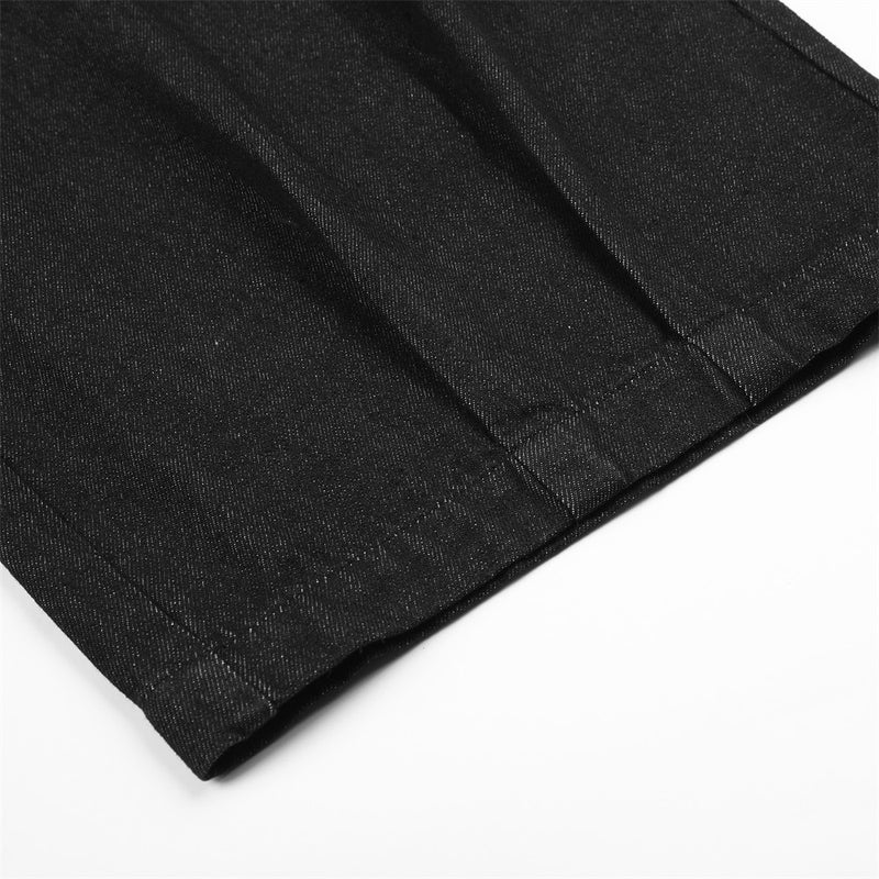 Close-up of black denim pant leg hem with visible seam stitching