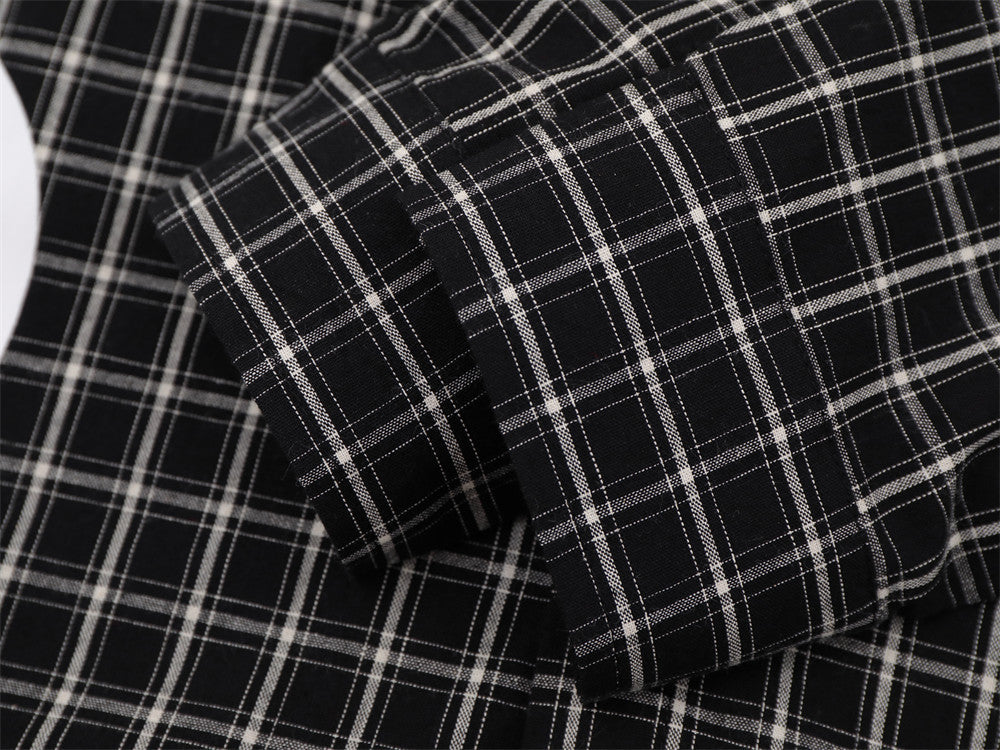 Close-up of layered black plaid shirt sleeves and cuff seams