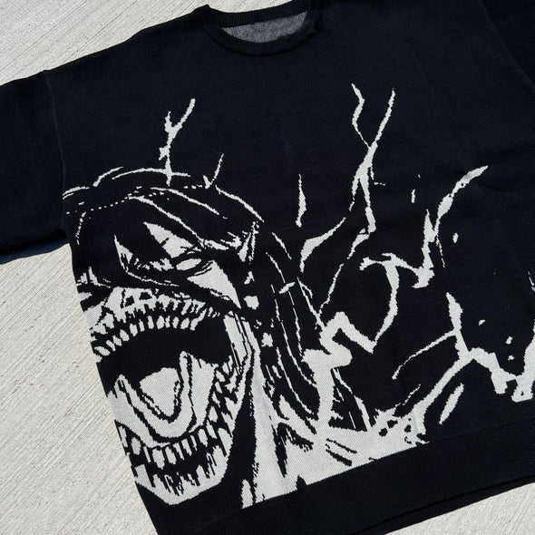 The Premium Attack on Titan-Inspired Knit Sweater by Attack on Titan features a white jacquard design of Eren Yeager's Titan form, showcasing a bold creature-like, open-mouthed face with prominent teeth and dynamic lines against grey. Ideal for fans of edgy streetwear style.