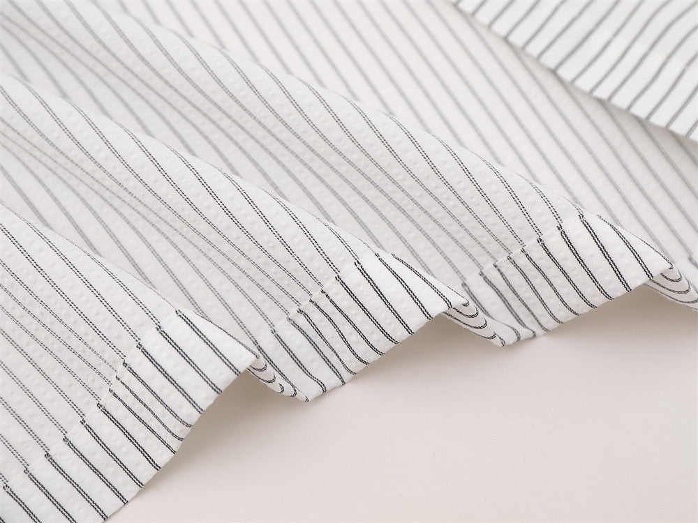Close-up of striped shirt hem and sleeve edge with fine vertical lines