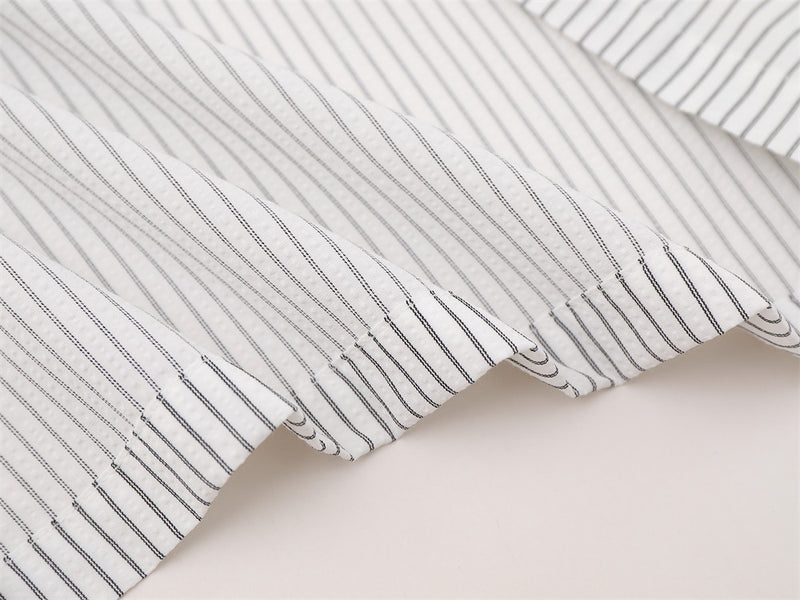 Close-up of striped shirt hem and sleeve edge with fine vertical lines