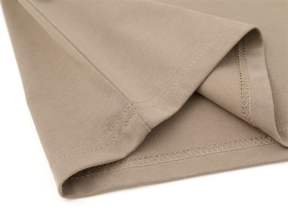 Close-up of khaki shirt hem with stitched seam and folded edge