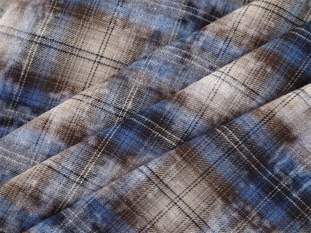 Close-up of folded plaid fabric showing blue, brown and beige pattern