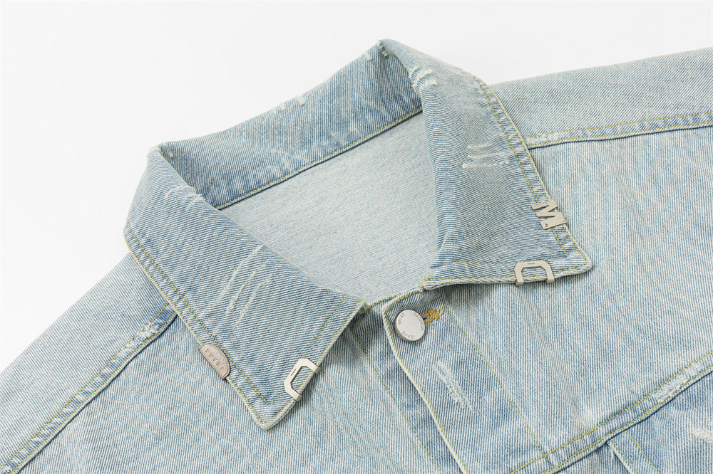 Close-up of the light wash denim jacket collar with stitching, metal buttons, and a small metal tab