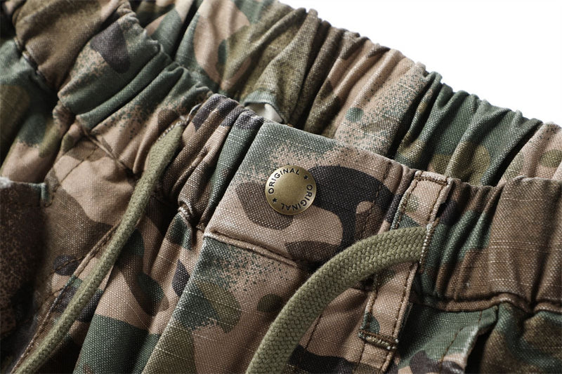 Close-up of camouflage shorts waistband button and drawstring detail