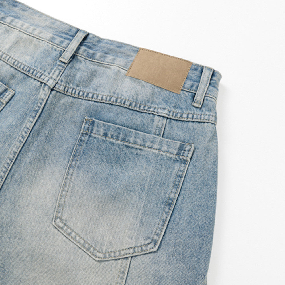 Close-up of back pocket and tan waistband patch on light blue denim shorts