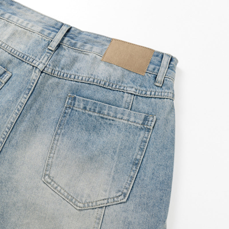 Close-up of back pocket and tan waistband patch on light blue denim shorts