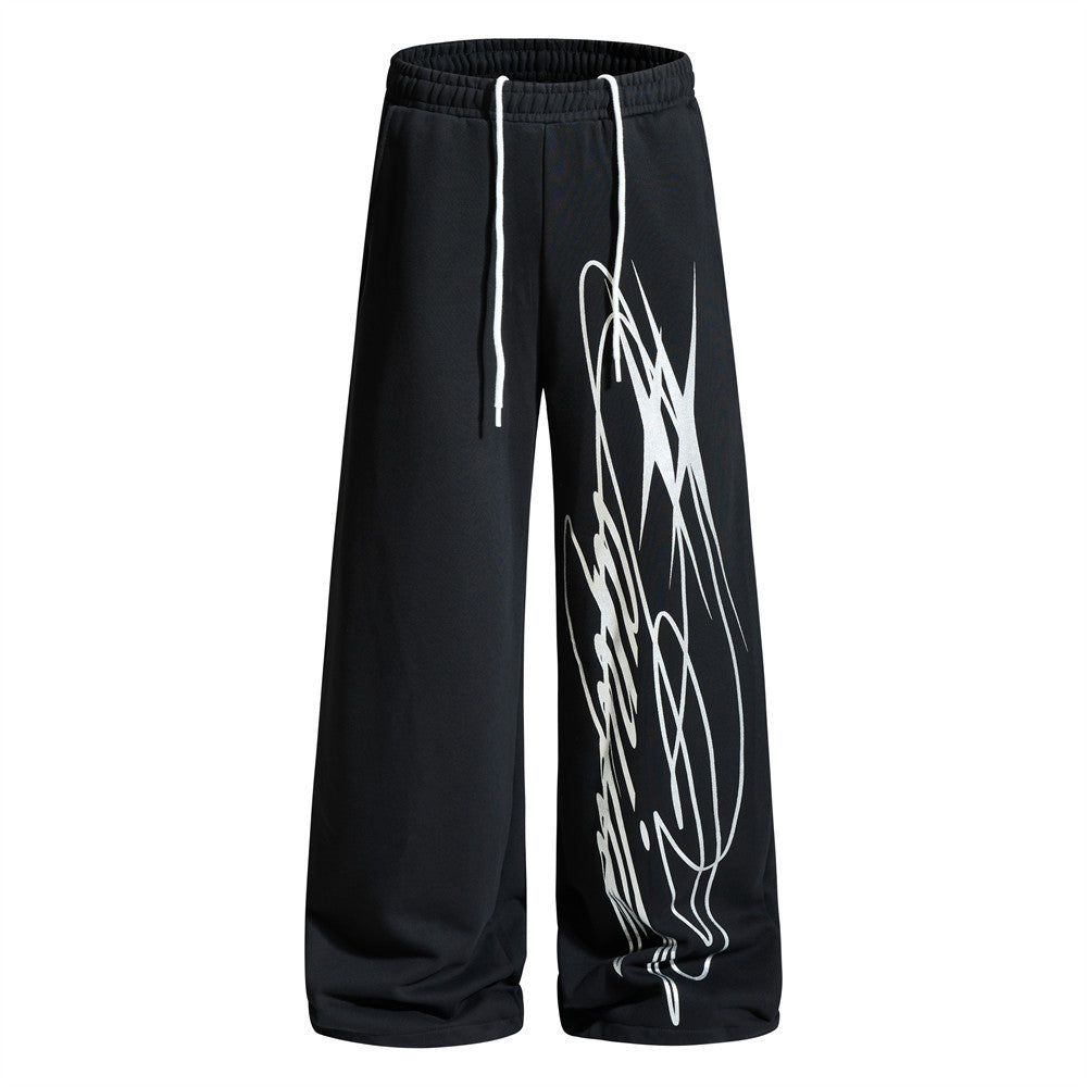 Wide-leg graffiti print sweatpants in black with white drawstring waist and bold diagonal graphic print