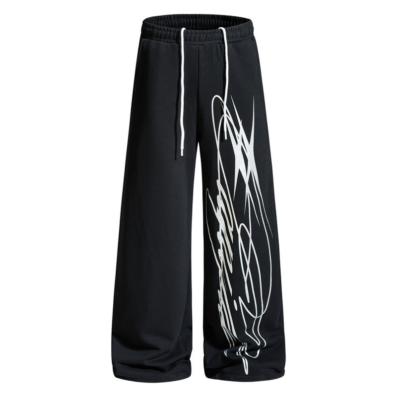 Wide-leg graffiti print sweatpants in black with white drawstring waist and bold diagonal graphic print