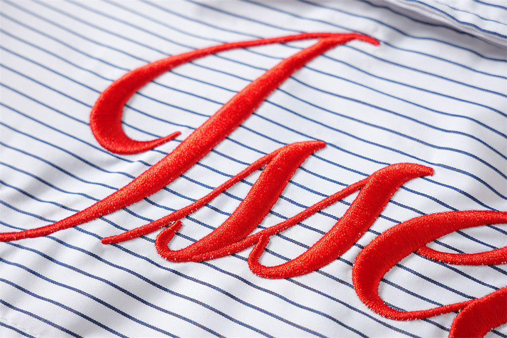 Close-up of large red embroidered script on blue striped fabric