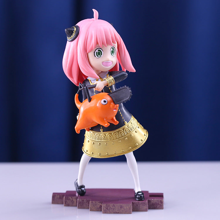 The Seakoff Anya Forger Chainsaw Cosplay Figure is an 18CM PVC action figure featuring the Spy x Family character with pink hair, green eyes, and a black and gold outfit. She stands on a purple base, holding an orange creature with a chainsaw nose against blue drapes.