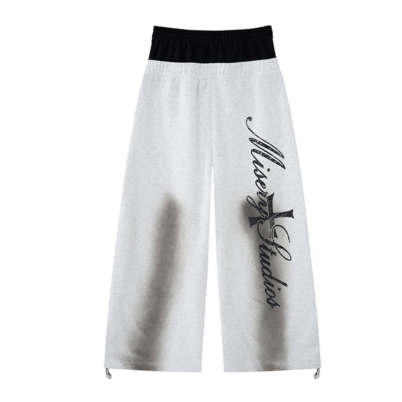 Pantalon de survêtement ample à jambes larges avec bandes latérales, fausse double ceinture et imprimé graphique