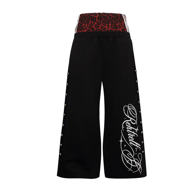 Weit geschnittene Sweatpants mit rotem Leopardenprint am Umschlagbund, silbernen Kugel-Nieten entlang der Seitennähte und geschwungenem Grafikprint
