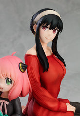 The Spy x Family Anya and Yor PVC Figure by Spy × Family, measuring 15 cm, captures an adorable mother-daughter moment with Yor in a red dress and long black hair, and Anya in a black outfit with pink hair and cat ear accessories, all set against a neutral gray backdrop.