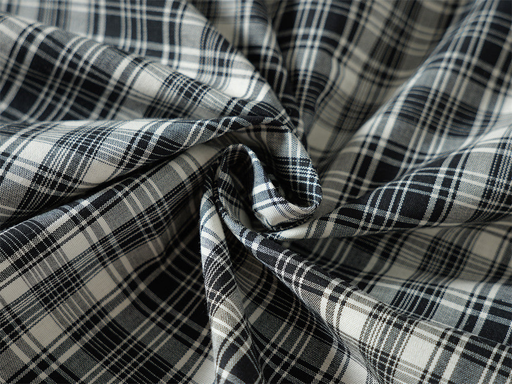 Close-up of folded black plaid shirt fabric showing the woven pattern