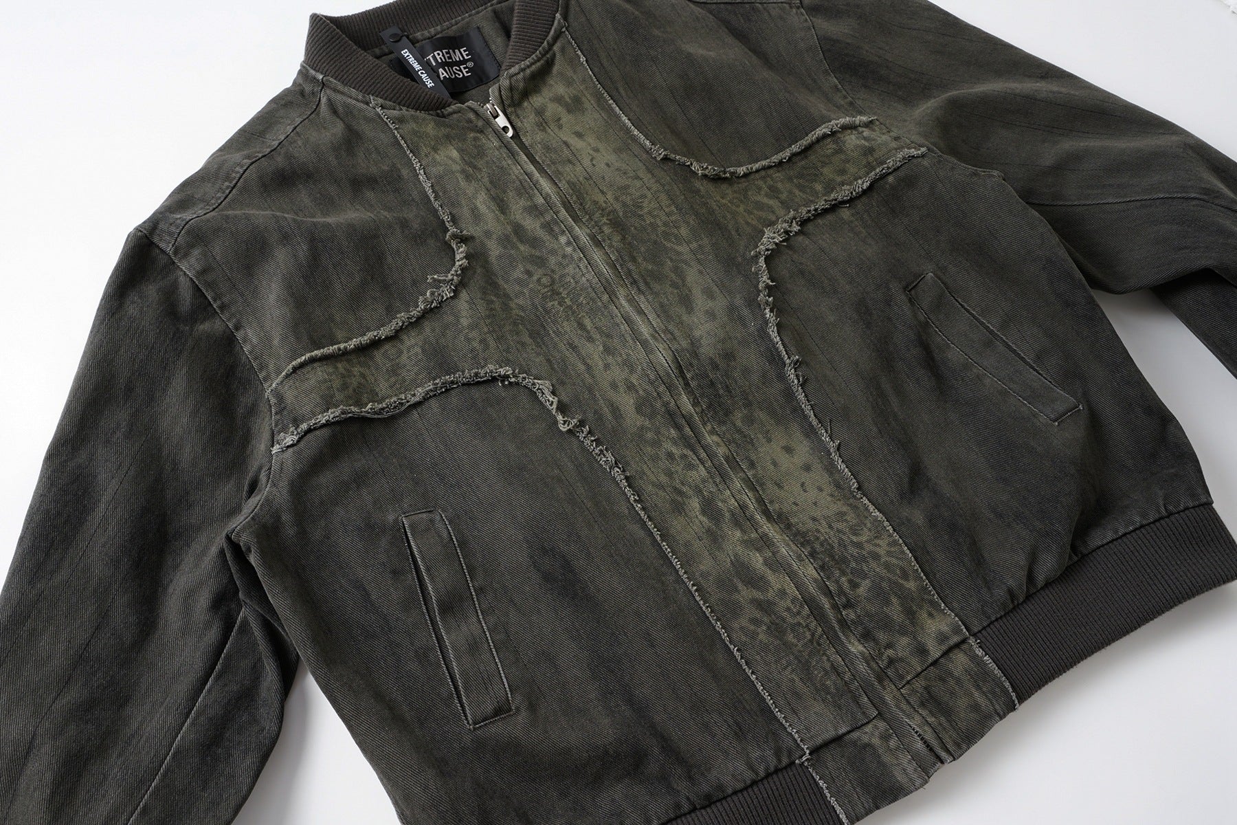 Veste bomber en jean délavé déconstruite à empiècement croisé et coutures effilochées