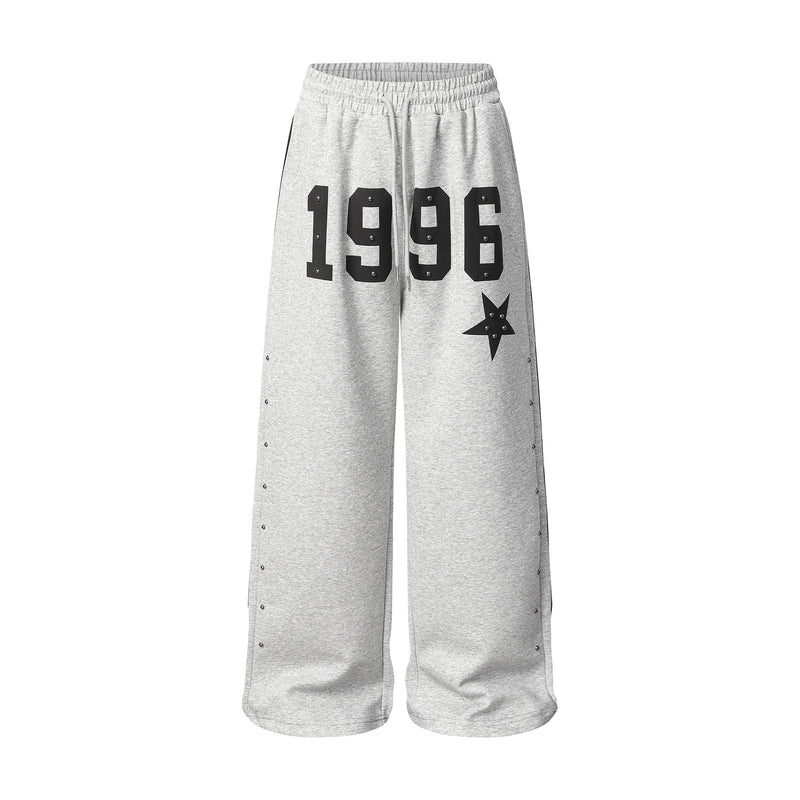 Pantalon de survêtement 1996 à jambes larges gris chiné, orné d’étoiles et de rivets métalliques, avec couture latérale à trois bandes