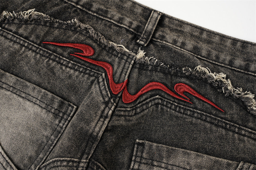 Close-up of the back waistband with red embroidered detail and frayed seam along the yoke