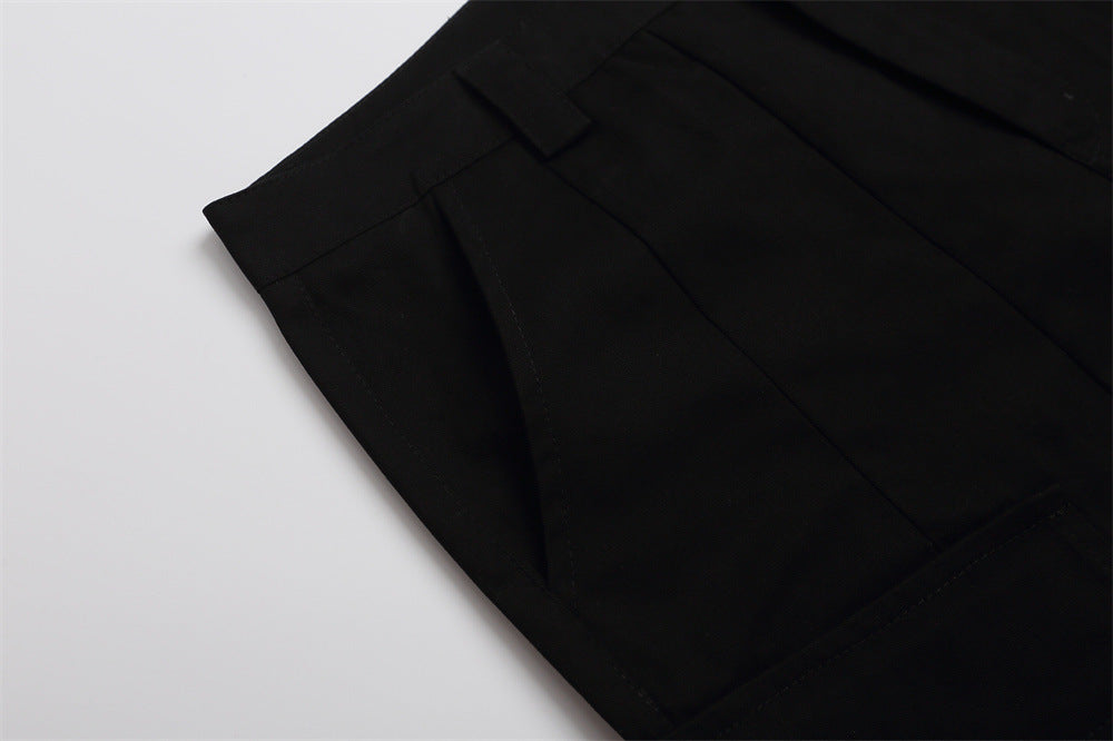 Close-up of black shorts side seam and pocket panel on white background