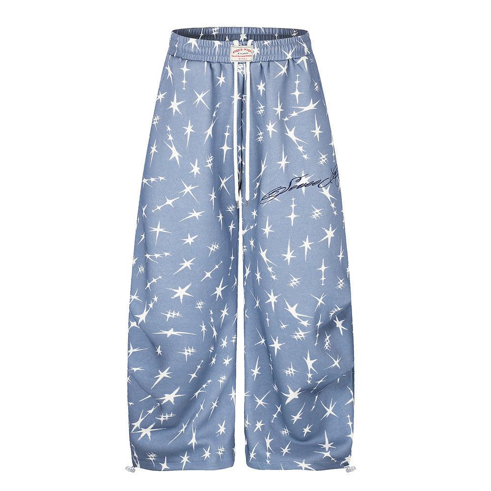 Men's dusty blue wide-leg sweatpants with all-over four-point star print, elastic drawstring waist and adjustable hem toggles