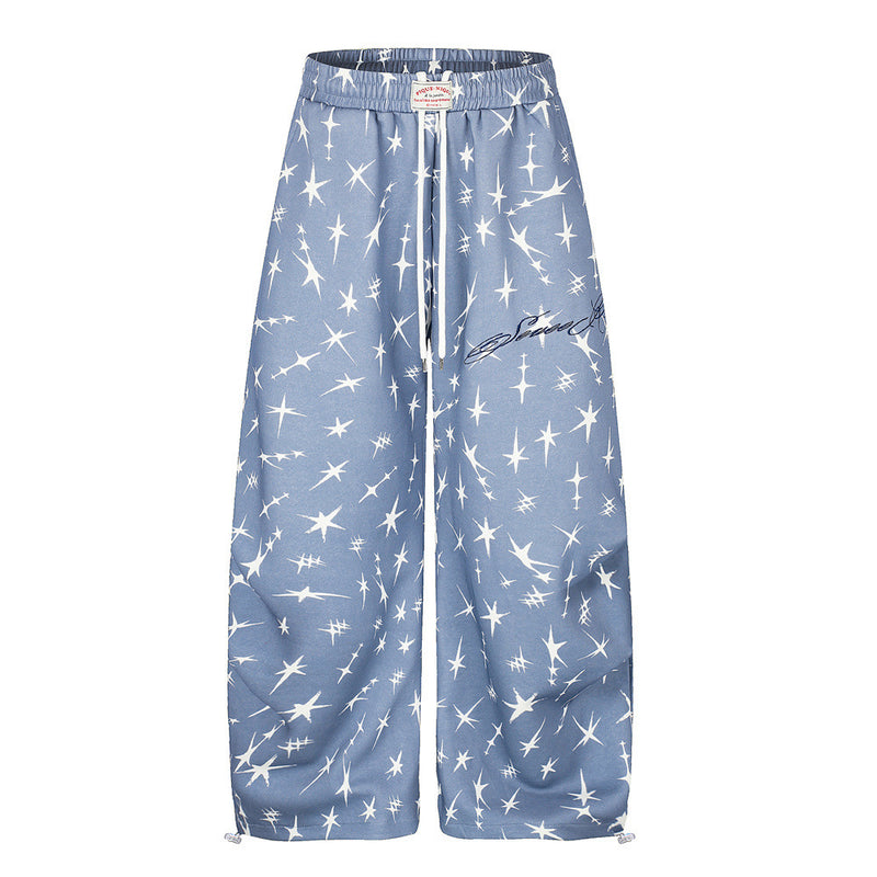 Men's dusty blue wide-leg sweatpants with all-over four-point star print, elastic drawstring waist and adjustable hem toggles
