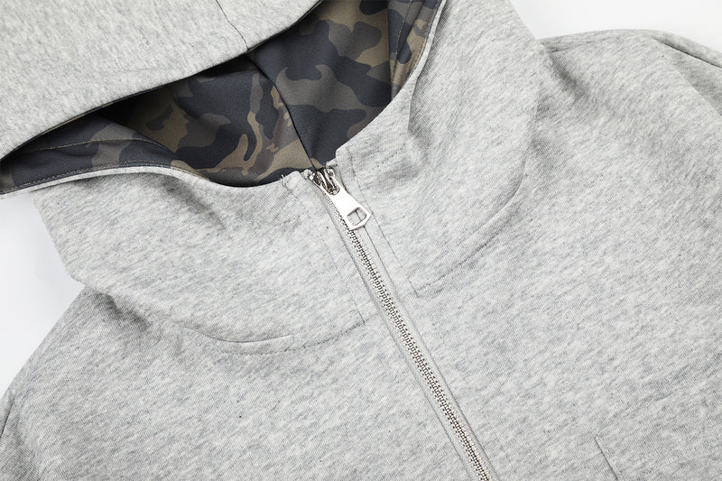 Sweat à capuche zippé avec écusson croix clouté et doublure camouflage