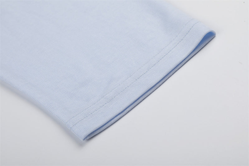 Close-up of light blue sleeve cuff with neat stitched hem