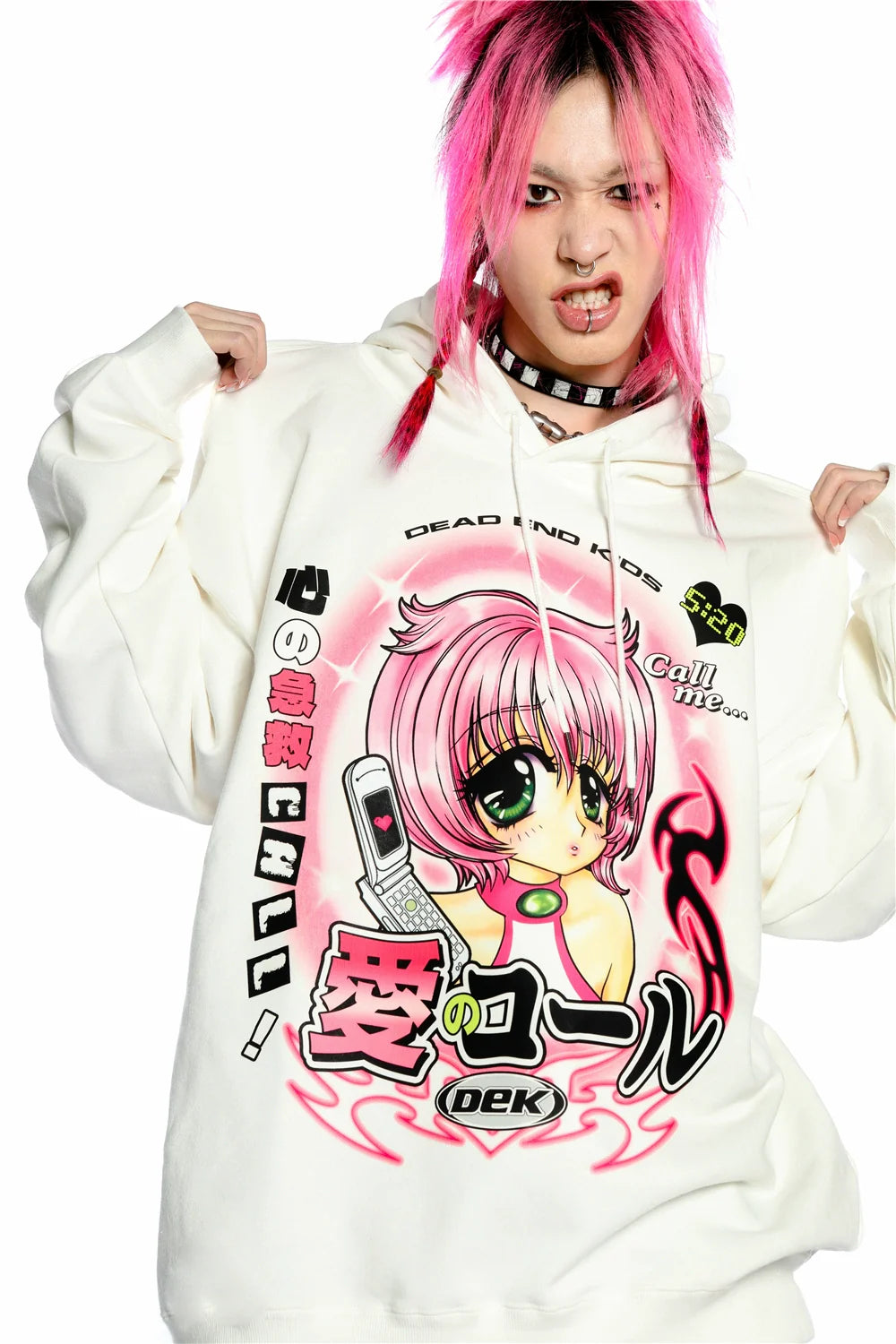 A person with pink hair poses fiercely in a Seakoff Y2K Aesthetic Anime Hoodie. The white pullover flaunts a retro manga girl graphic, big eyes, and a kawaii phone design. Flames and Japanese text add flair with "Dead End Kids.