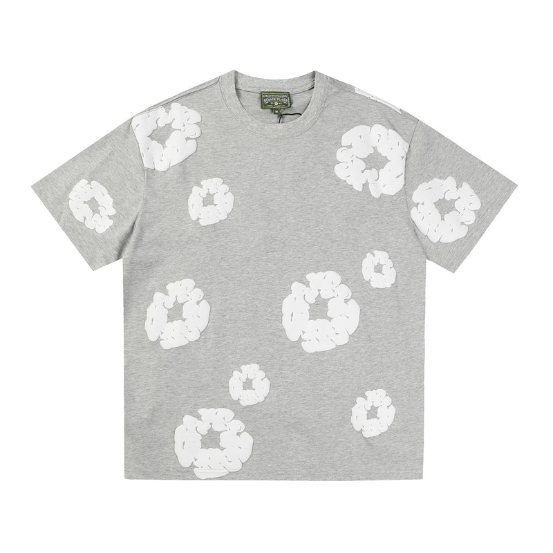 Denim Tears grey heather T-shirt with allover white wreath print on front body and sleeves, laid flat on white background
