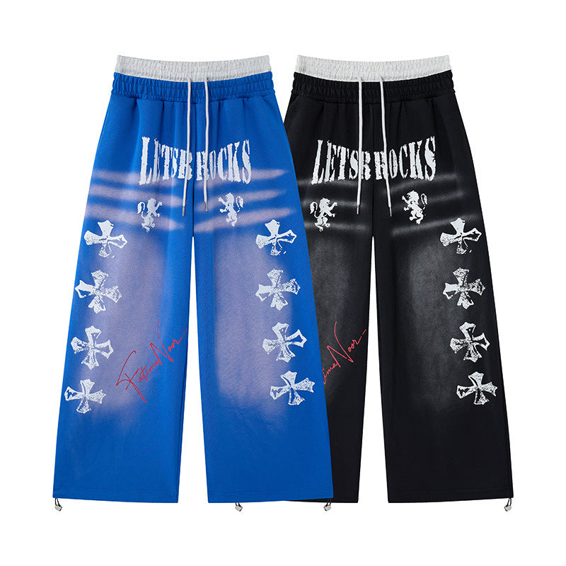 Pantalon de survêtement à jambes larges avec imprimé graffiti de croix et fausse double ceinture, coloris noir et bleu