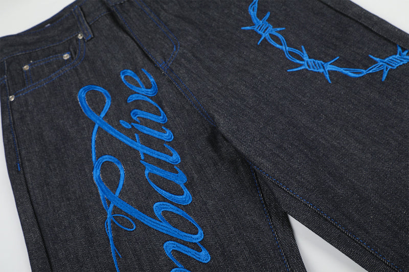 Jean baggy à jambes larges avec broderie bleue effet script et fil barbelé