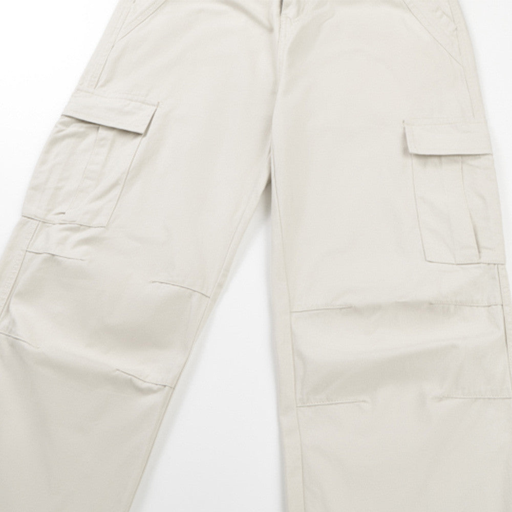Close-up of cream cargo pants with flap side pockets on the leg