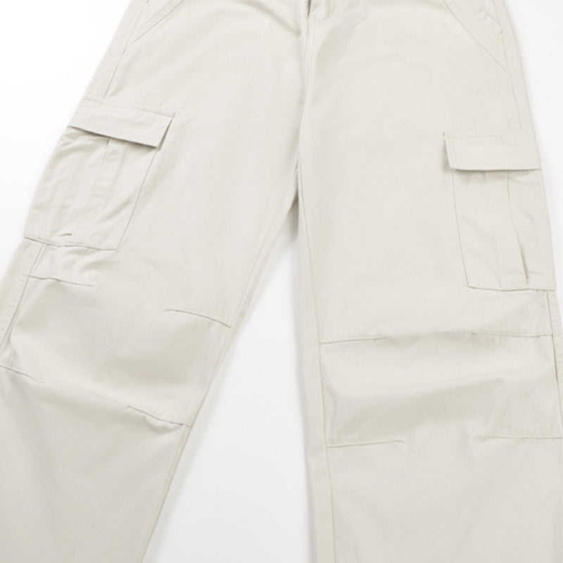Close-up of cream cargo pants with flap side pockets on the leg