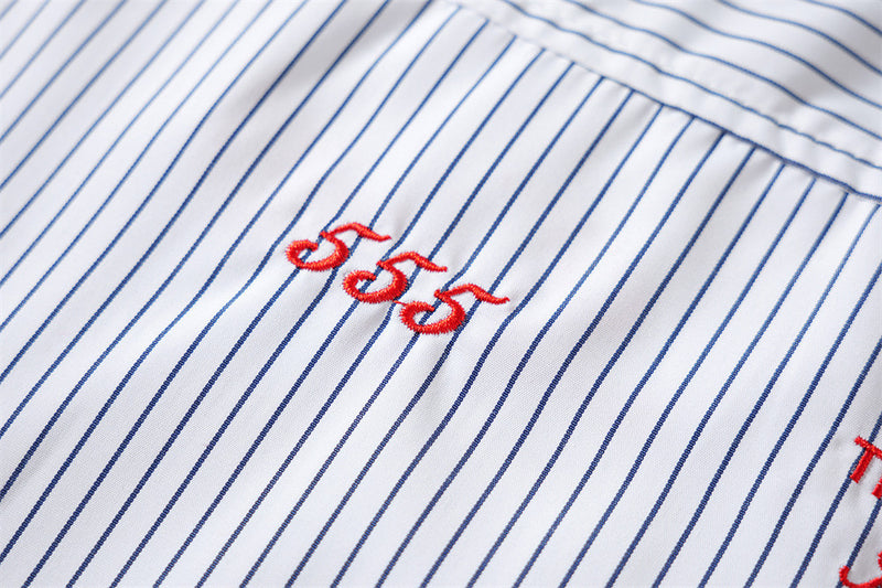 Close-up of small red embroidered numbers on striped fabric