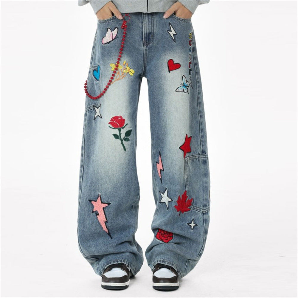 Vaqueros baggy de pierna ancha en azul lavado, cubiertos de flores, mariposas, estrellas, rayos bordados y aplicaciones de patchwork
