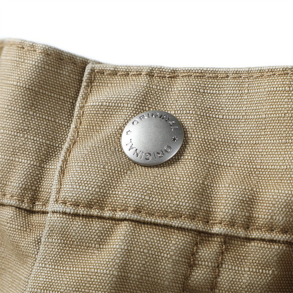 Close-up of khaki shorts waistband with round metal snap detail